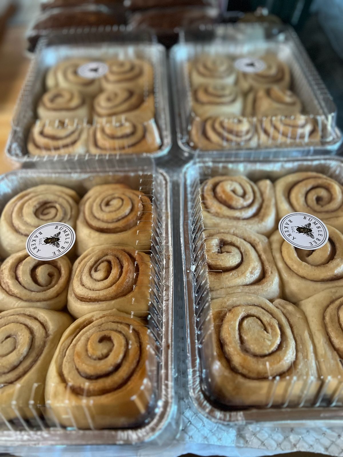 Pans of cinnamon rolls with Bumble Bee Bakery stickers