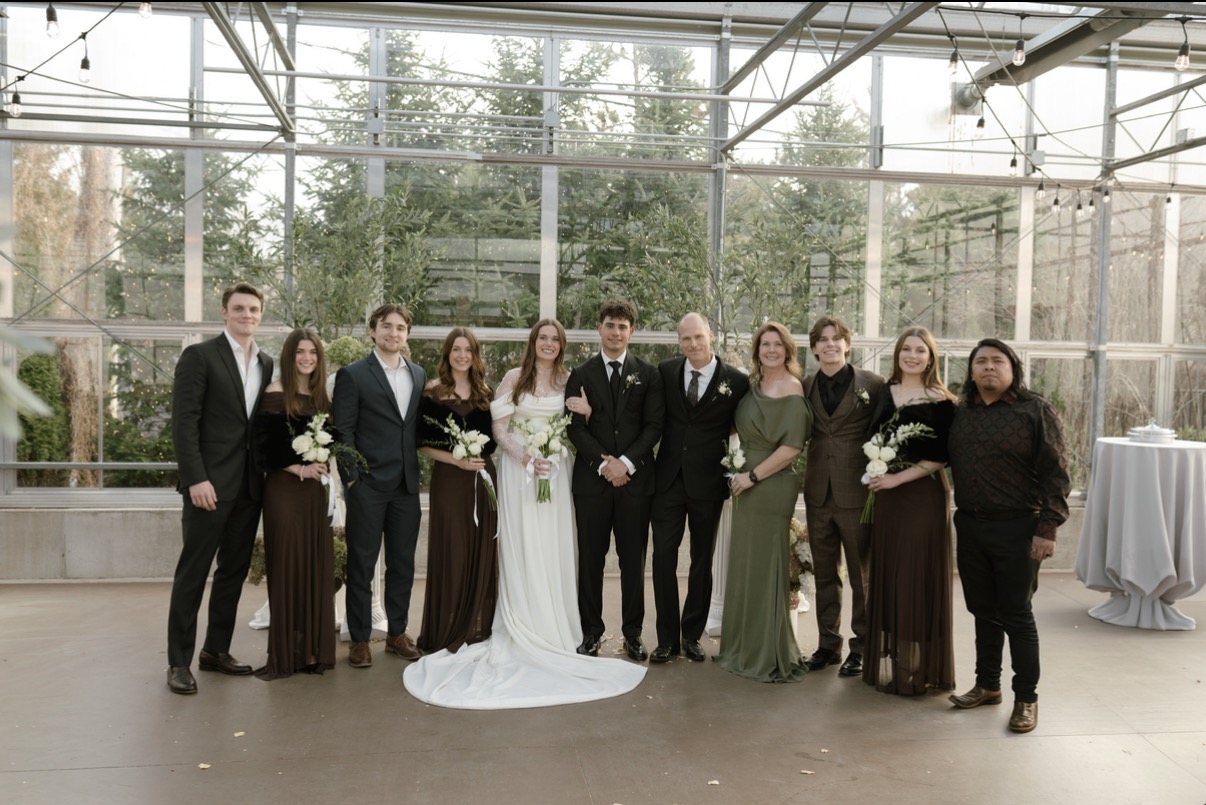 Our family together at a wedding in a glass greenhouse venue
