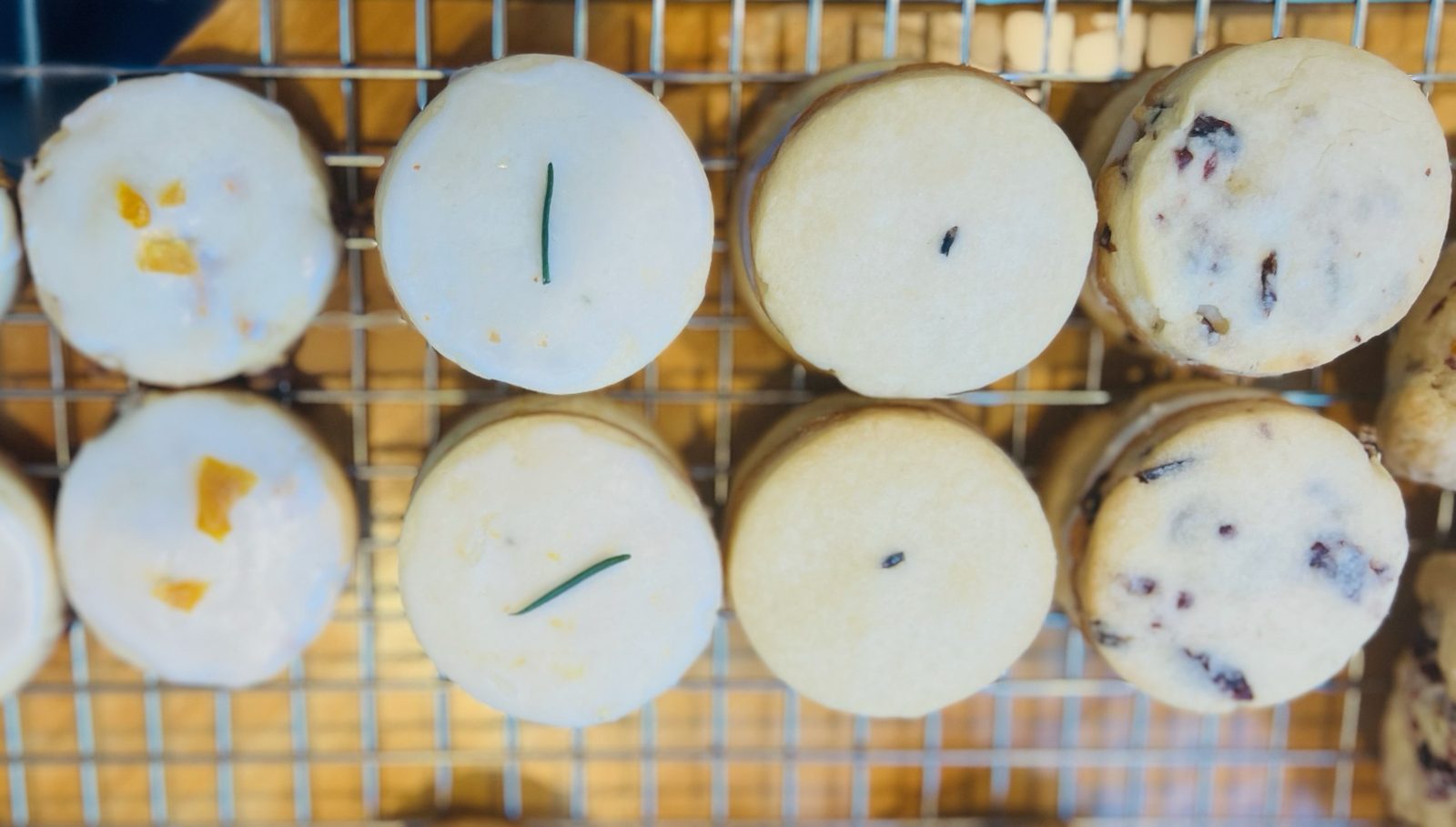 Shortbreads cooling on a wire rack: glazed mango, iced lemon rosemary, lavender and cranberry pecan