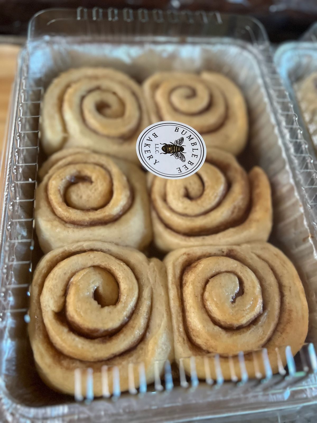 A pan of cinnamon rolls sealed with a Bumble Bee Bakery sticker