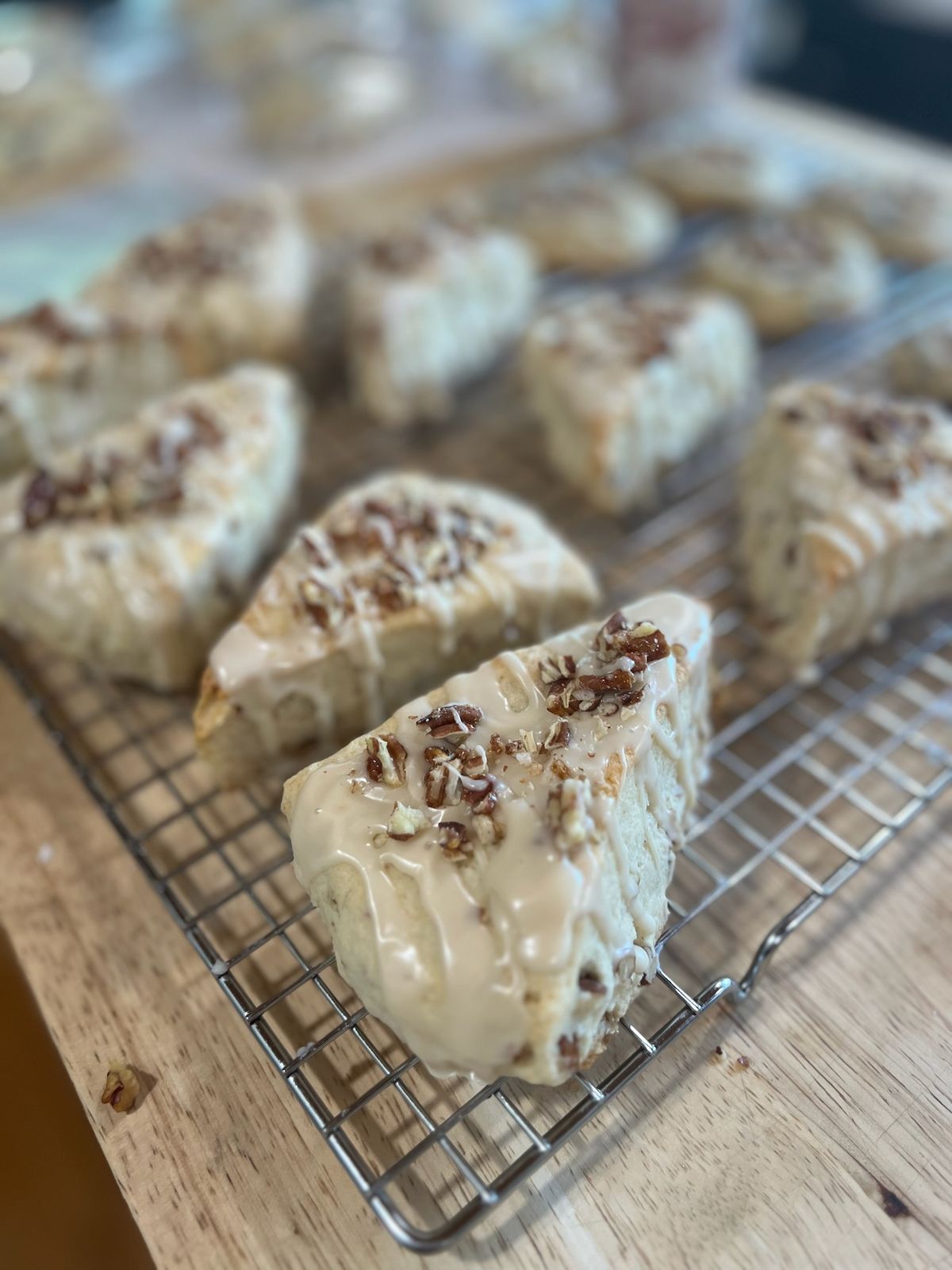 Maple pecan scones with maple glaze and toasted pecans, cooling on a wire rack
